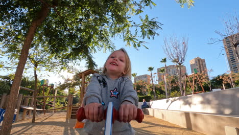 Niño-Alegre-En-El-Balancín-En-El-Patio-De-Recreo