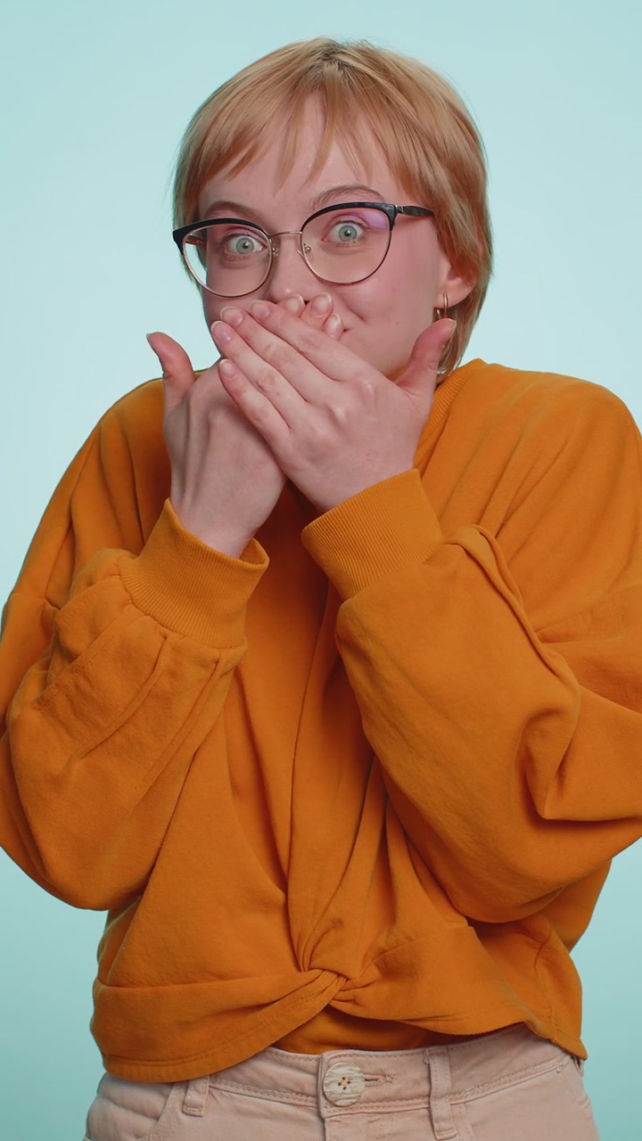 Frightened woman closing mouth with hands refusing to tell terrible secret unbelievable truth