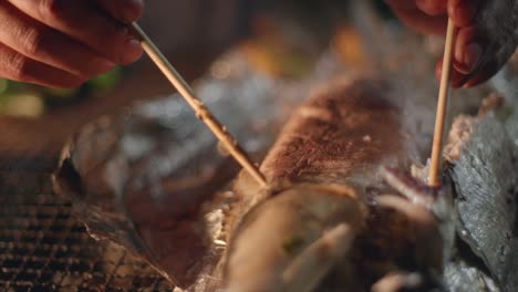 Piel-De-Pescado-Recién-Horneado-A-La-Parrilla-En-Papel-De-Aluminio-Retirado-Usando-Palillos-A-Mano,-Filmado-Como-Primer-Plano-En-Cámara-Lenta