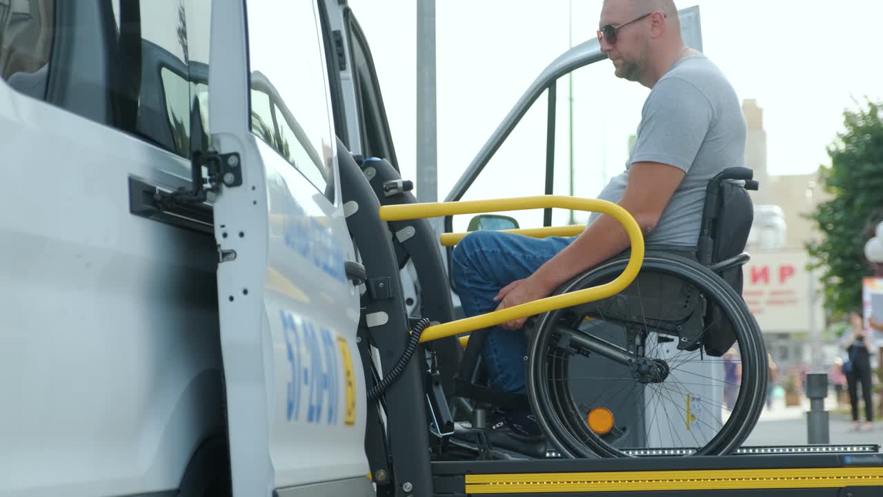 A man in a wheelchair on a lift of a vehicle for people with disabilities. Lifting equipment for people with disabilities - man in wheelchair near the vehicle