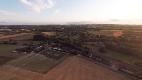 flying slowly across beautiful rolling fields being lit by an orange sunset