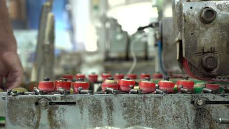 trabajador con camisa roja que trabaja detrás de una máquina industrial en una antigua fábrica