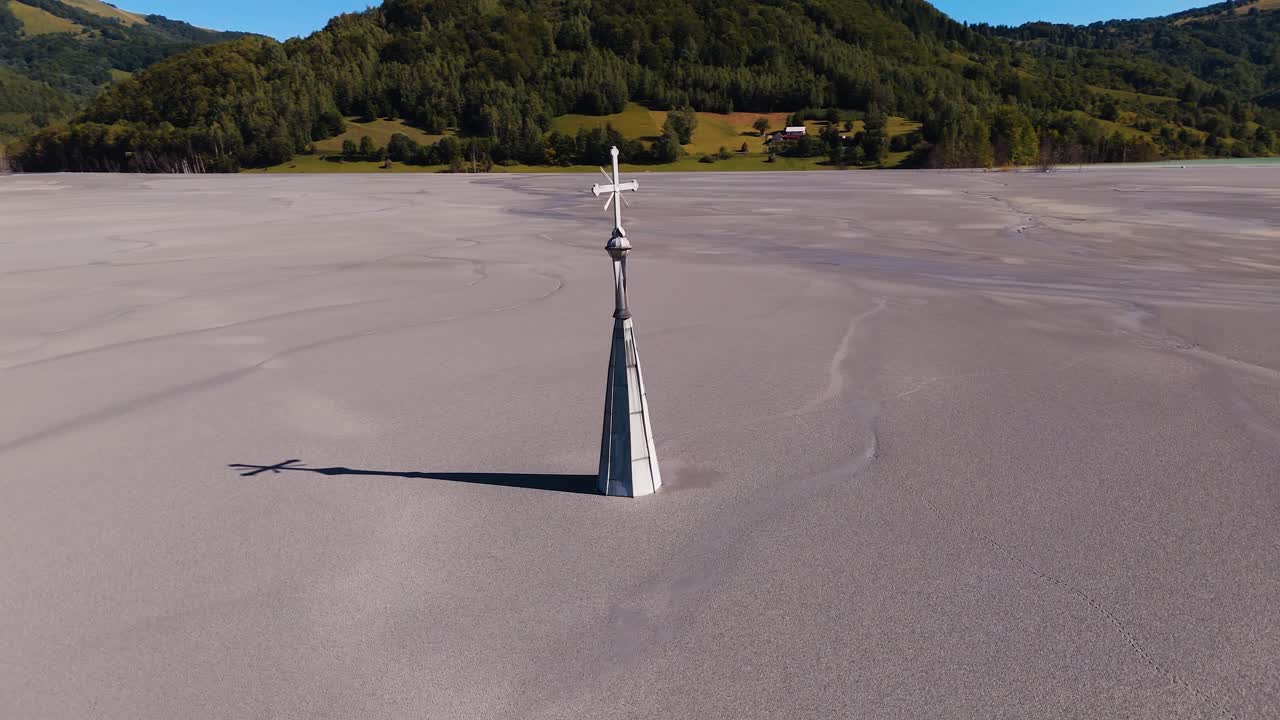 Il drone orbita attorno alla torre della chiesa che emerge dai rifiuti minerari a Geamăna