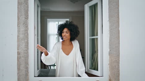 curly lady catching raindrops at window place. woman watching at rainy weather