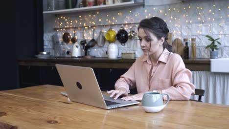 woman working on laptop in a kitchen