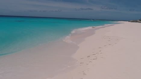 couple enjoy luxury caribbean beach camp, drone shot dolly out cayo de agua island