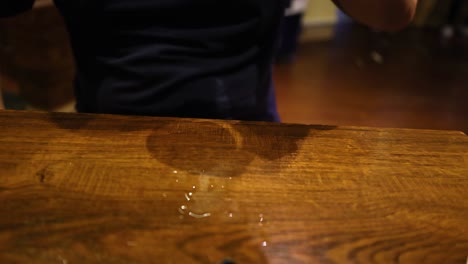 hombre mueve un vaso de cerveza en la mesa