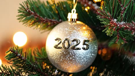 silver christmas ornament with 2025 on a christmas tree