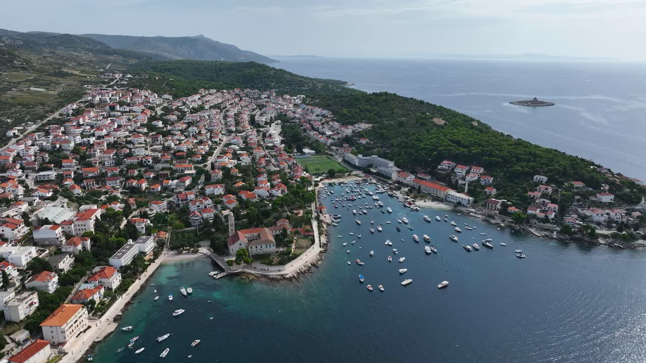 Aerial establishing overview of Hvar Island, Croatia, showcasing the coastline, blue waters, and historic town on stunning beautiful day