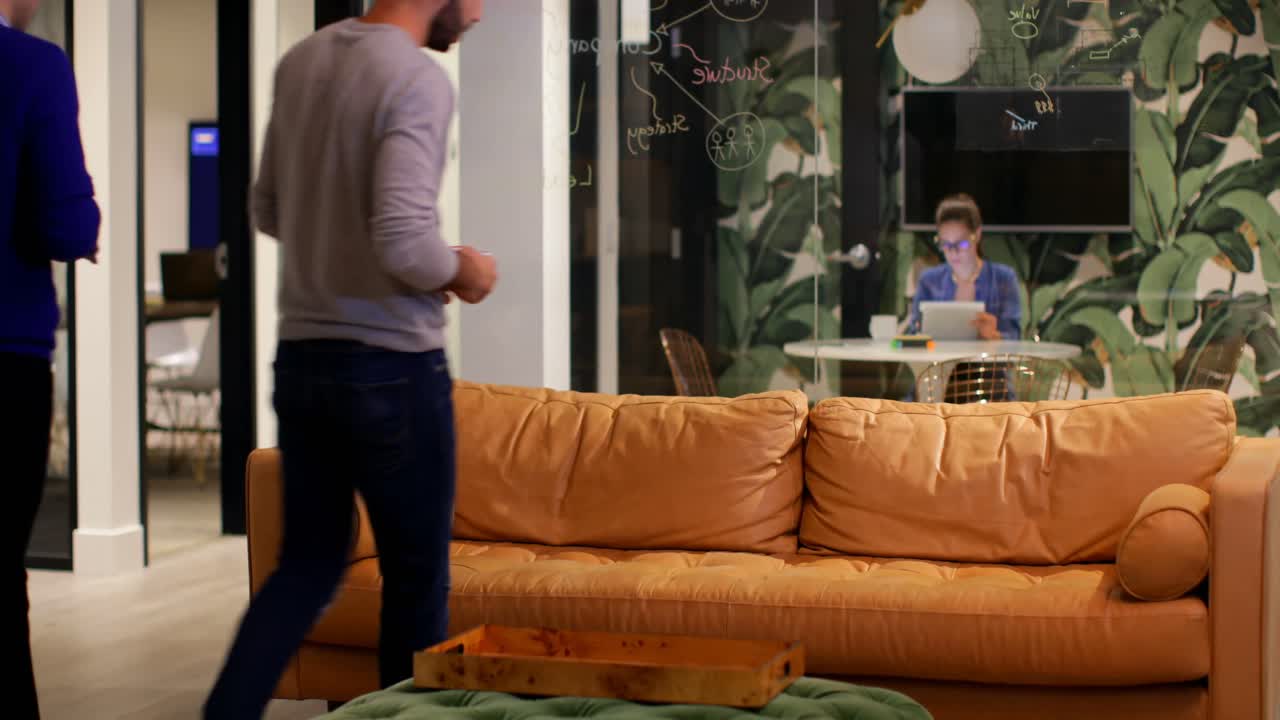 사무실 4k의 소파에서 커피를 마시는 비즈니스 임원들