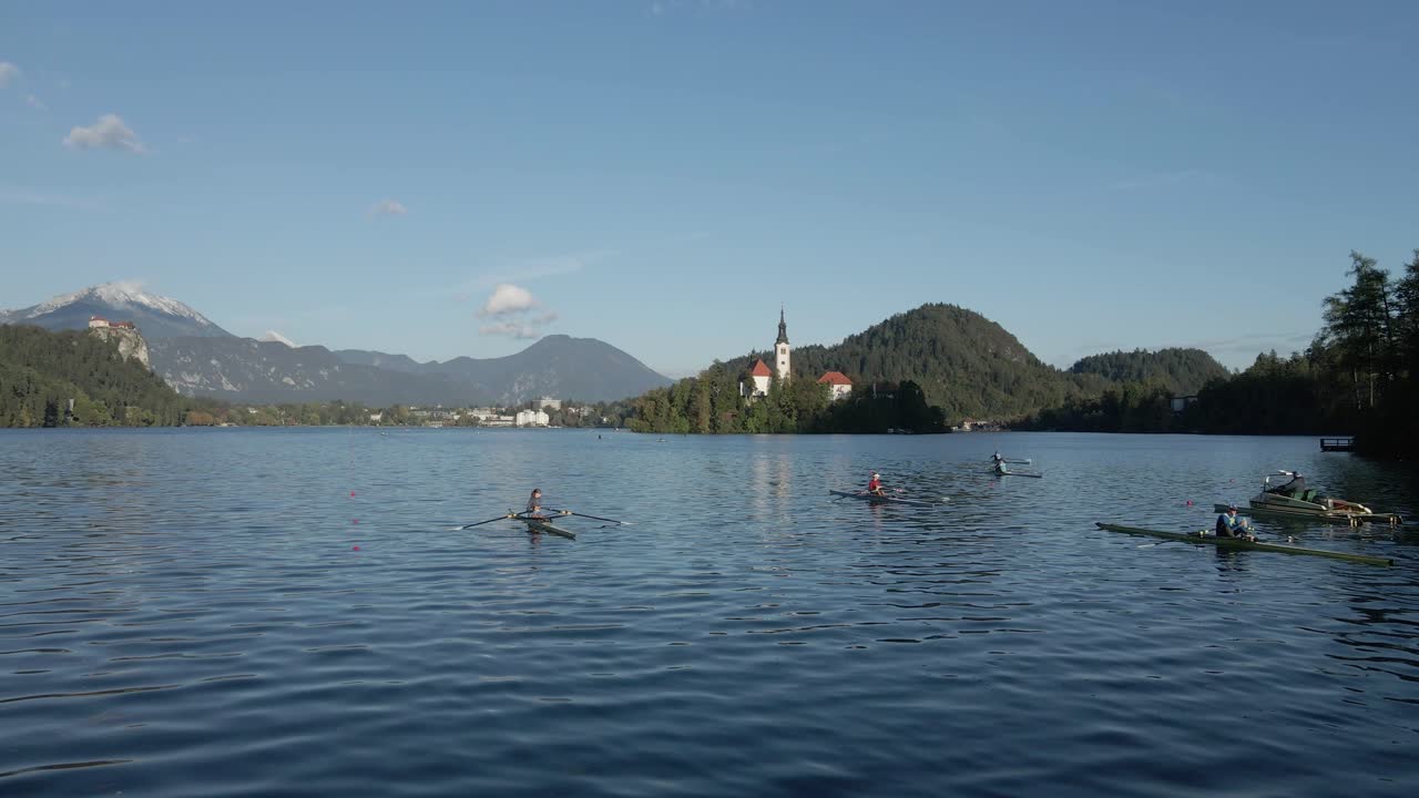 Roeiers op het Meer van Bled met kerkeiland in de herfst, Julische Alpen, Slovenië.