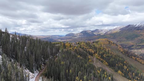 scenic road in coniferous forest and natural landscape of rocky mountains during fall