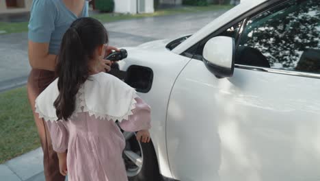 estilo de vida progresivo de madre e hija con coche eléctrico y estación de carga.