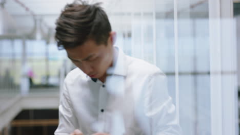 young-asian-businessman-using-smartphone-walking-up-stairs-texting-messages-on-mobile-phone-sending-email-communication-networking-online-at-work-in-office