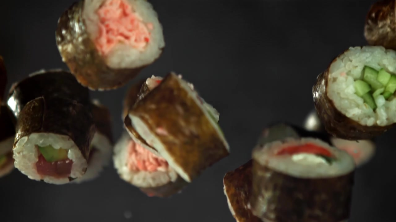 Deliziosi sushi roll giapponesi che cadono al rallentatore
