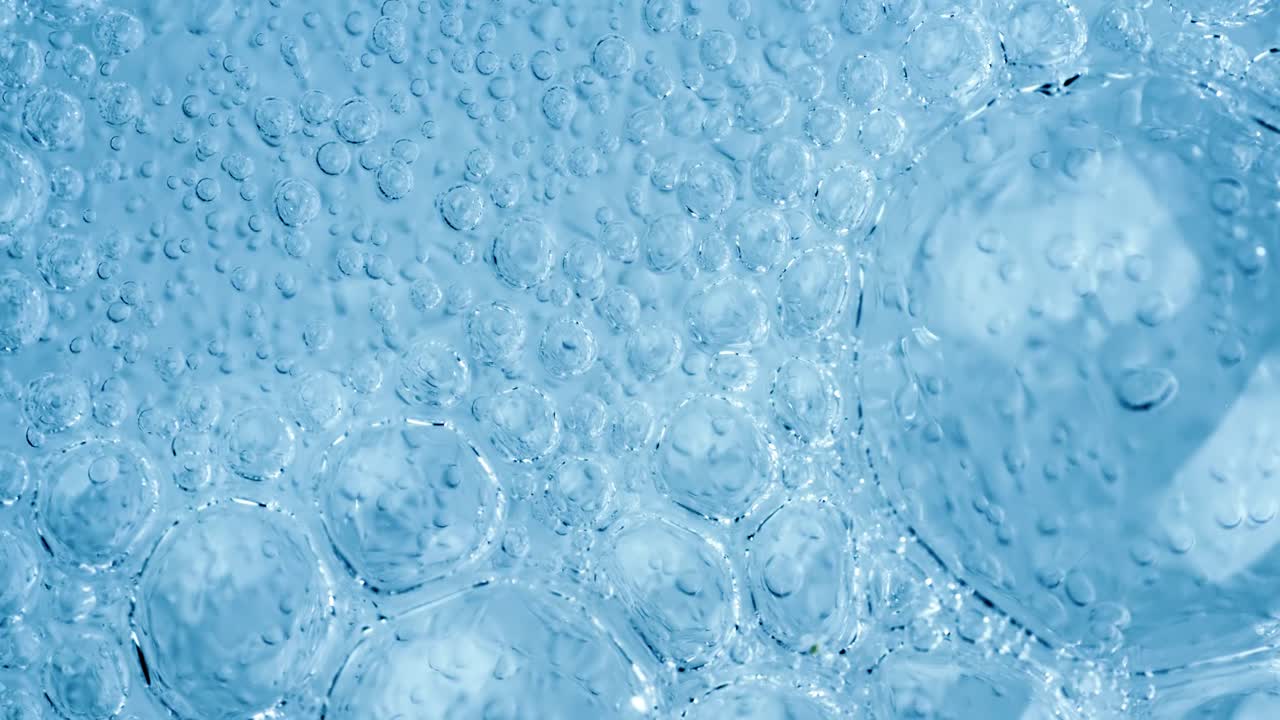 슈퍼 슬로우 모션으로 파란색 추상적인 배경에 물에 산소 거품이 있습니다.