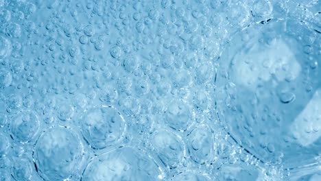 oxygen bubbles in water on a blue abstract background on super slow motion.