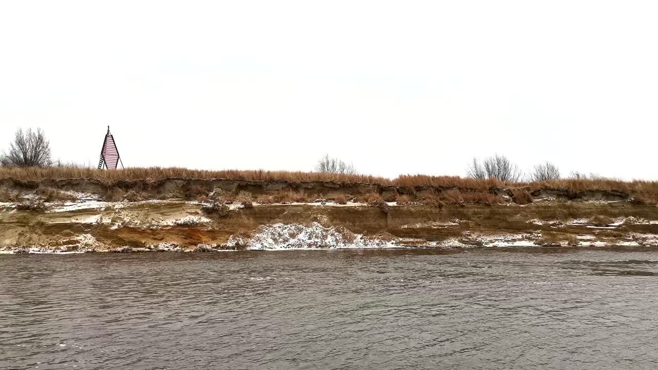 orilla del río en invierno con un punto de referencia
