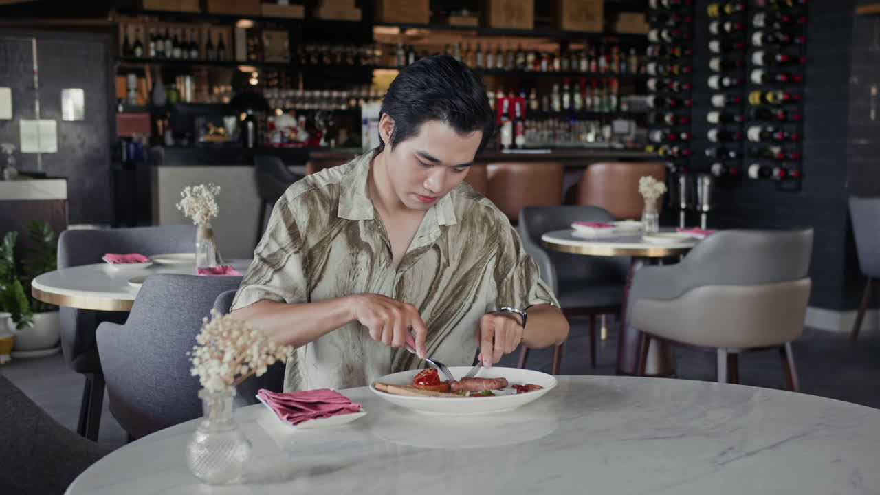 Young Waitress Bringing Cocktail to Man Dining in Restaurant