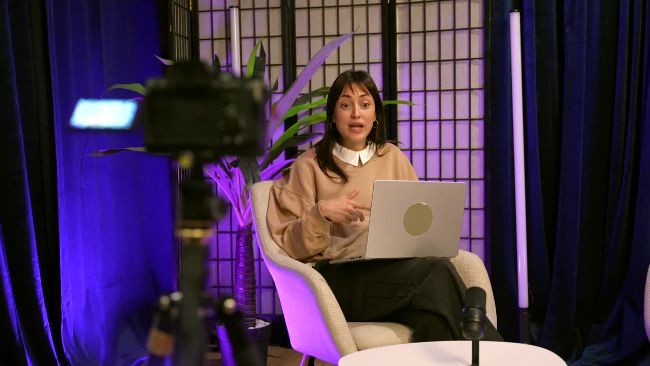 Giovane donna che registra una presentazione video online in uno studio moderno