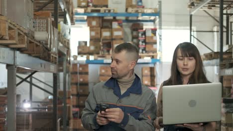 employee takes inventory using scanner of large distribution center