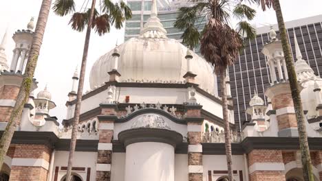 Blick-Auf-Die-Moschee-Im-Alten-Architekturstil-Durch-Palmen-In-Kuala-Lumpur,-Malaysia