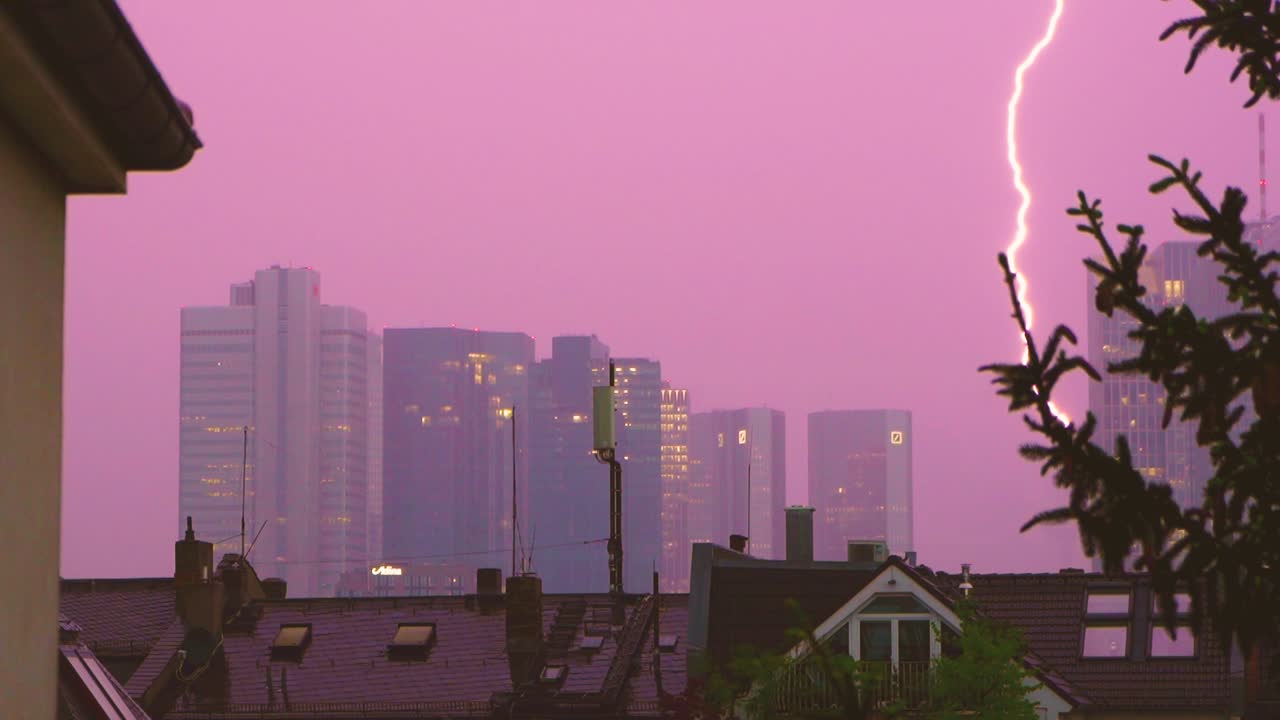 Lightning strikes near city skyline during a stormy evening with dramatic atmosphere