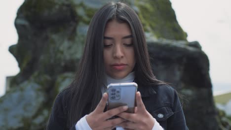 close up of a young hispanic woman using her smartphone