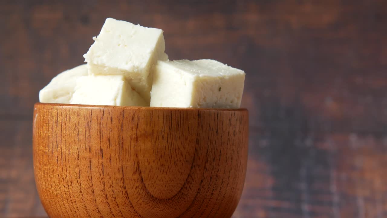 cubos de paneer en un cuenco de madera