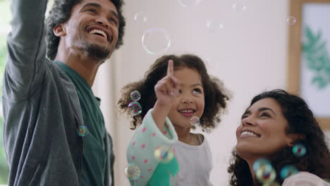 Linda-Niña-Jugando-Con-Pompas-De-Jabón-En-Casa,-Madre-Y-Padre-Divirtiéndose-Con-El-Niño-Disfrutando-Del-Tiempo-En-Familia-El-Fin-De-Semana-4k