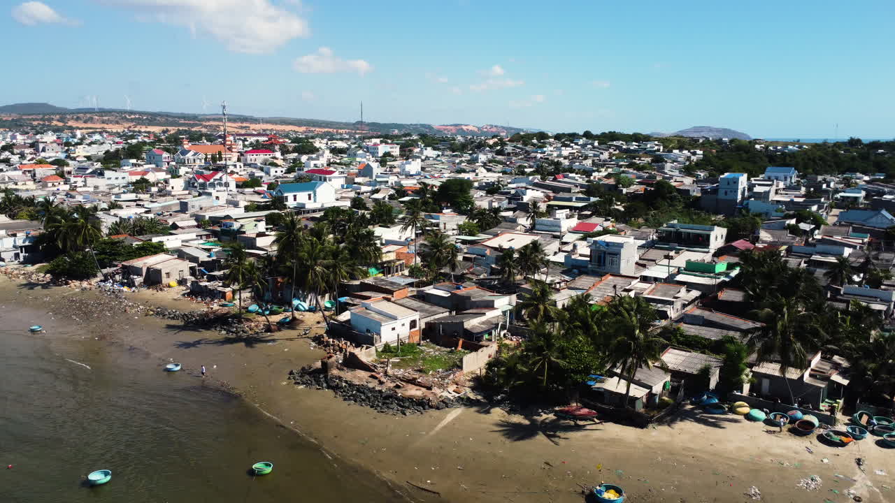 Coiffed trees on historic coconut jungle Vietnam makes place for polluted beach dirty boats, and life in vietnamese countyside, Backwards drone dolly shot