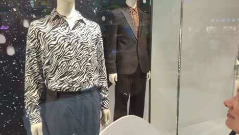 woman looks at fashion she does not like in a mall shopping window