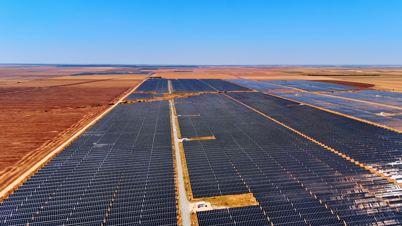 Vast solar farm in clear sky. A vast solar panel farm spans an open landscape, harnessing sunlight efficiently on a sunny day