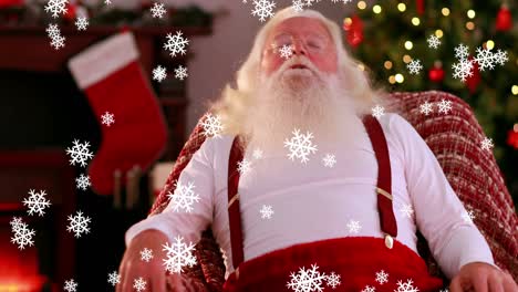 snowflakes falling against santa claus sleeping on a chair