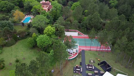 pan down from tennis court to white wedding tent for celebration