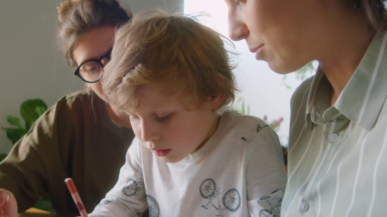 Child Studying at Home with Help of Lesbian Parents