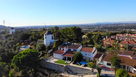 Drohnenaufnahme-Einiger-Häuser-Und-Windmühlen-Auf-Dem-Bergrücken-Von-Palmela,-Portugal