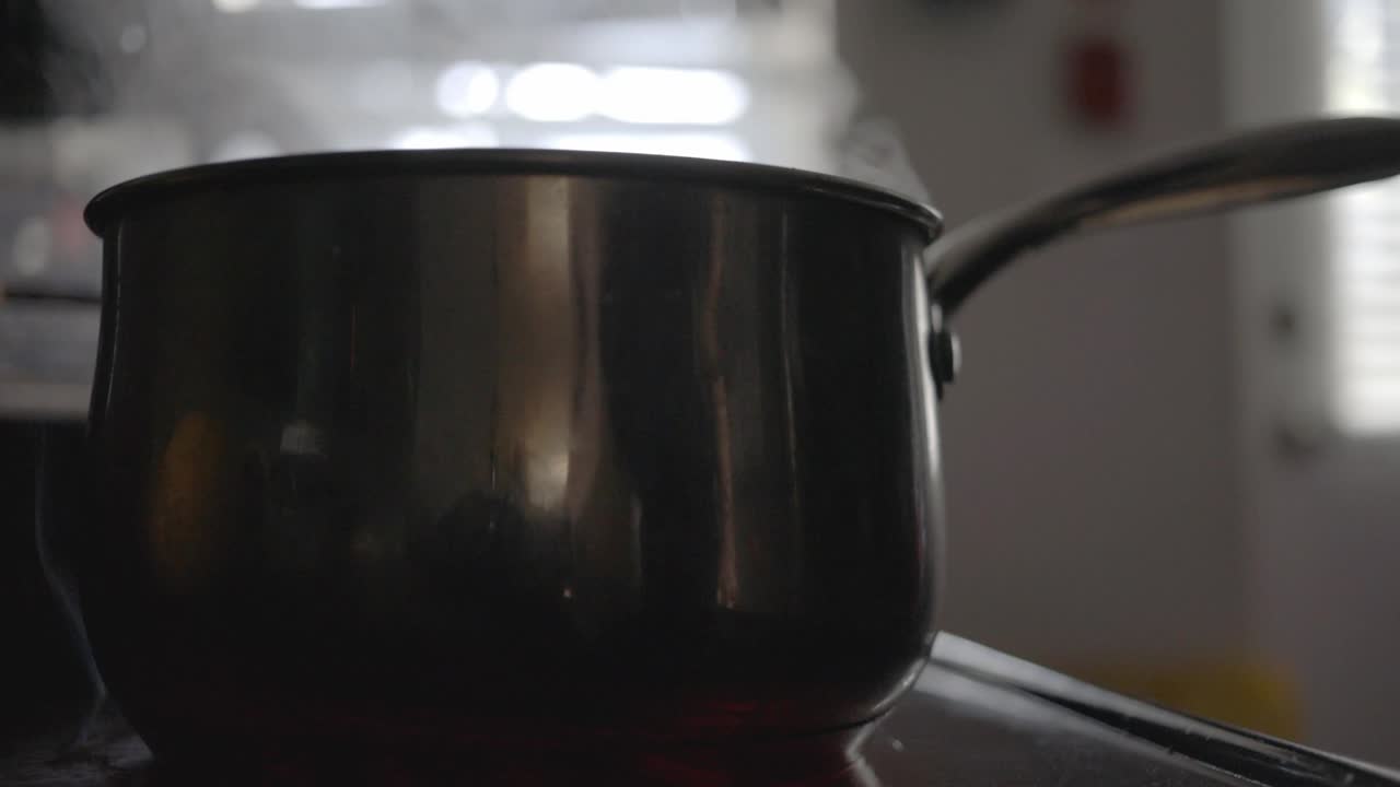 Steaming Black Pot On Top Of The Electric Gas Stove In The Kitchen.- close up shot