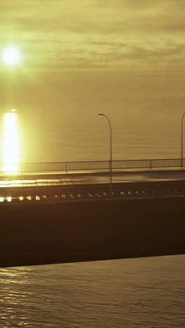 stunning sunrise over waterfront bridge with shimmering reflections on water