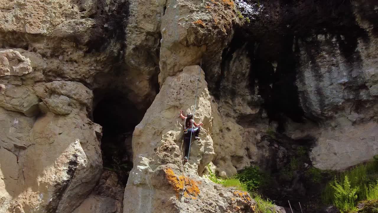 Adventurous Female Climber Climbing On Rugged Cliff Near Huaraz In Peru. arc shot