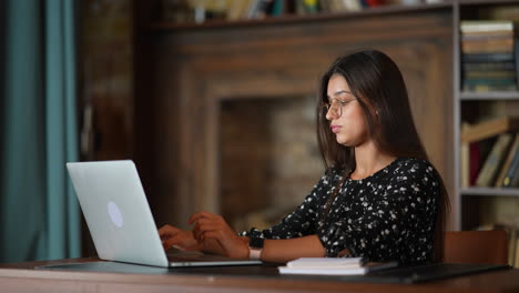 mujer trabajando en una computadora portátil en una oficina acogedora