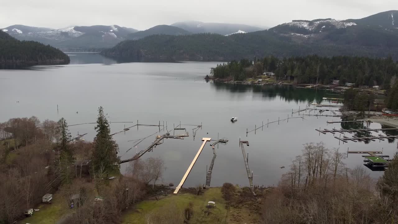 Droneopptak av innsjø, snødekte fjell med brygger på Vancouver Island i Canada
