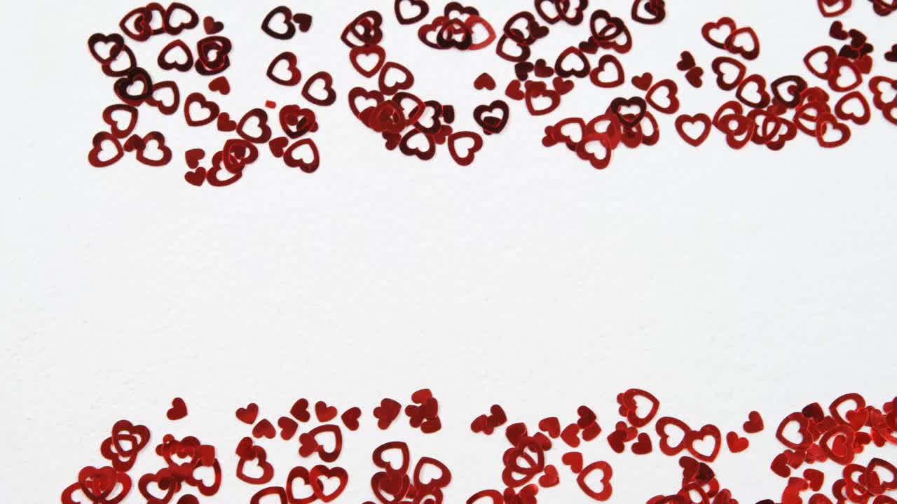 Coriandoli rossi a forma di cuore su superficie bianca 4k