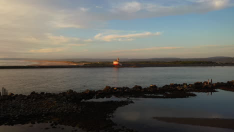faro del río coquille en bandon, oregon con un río tranquilo que fluye en primer plano - tiro estático amplio