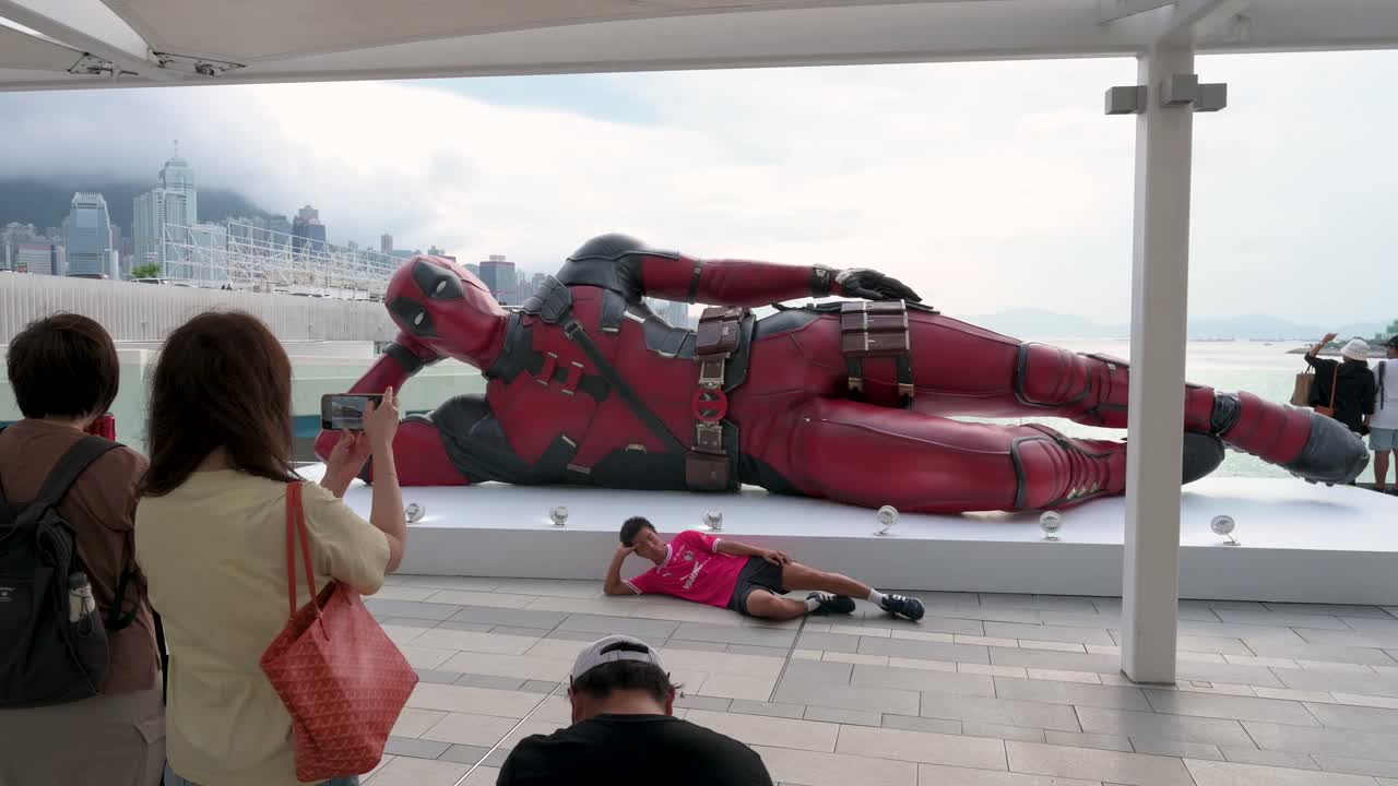 Against Hong Kong’s skyline, an 8-meter Deadpool installation draws locals and tourists, who snap photos to mark Disney’s "Deadpool and Wolverine" film promotion.