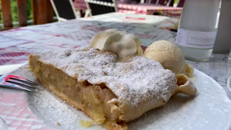 Delicioso-Strudel-De-Manzana-Con-Helado-En-Un-Plato-Con-Azúcar,-Un-Manjar-Austriaco-Muy-Famoso