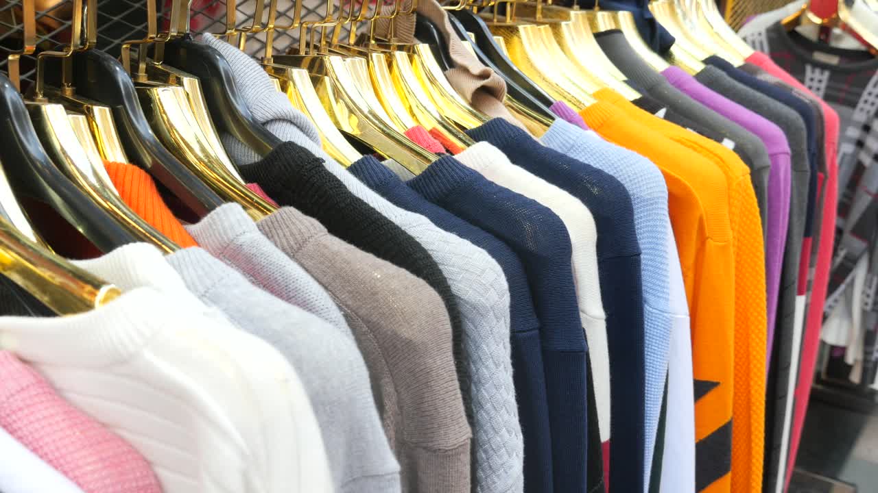 suéteres coloridos en colgadores en una tienda