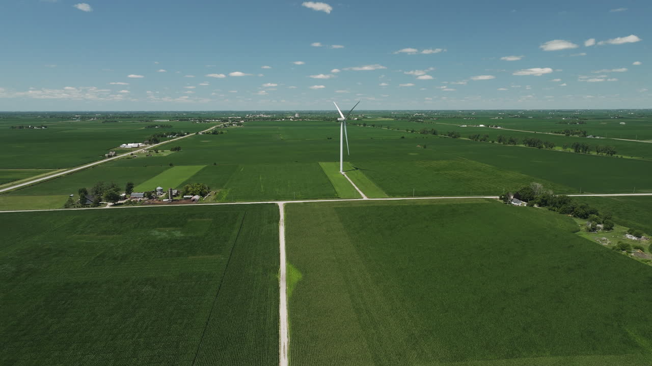 Aerial of a wind turbine in the distance and another revealed after zoom out