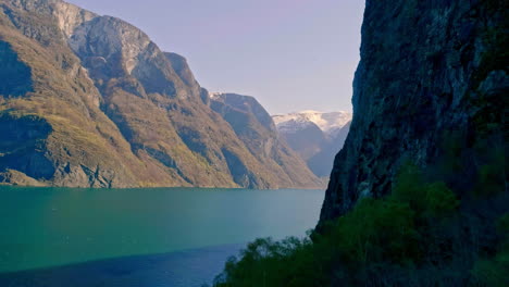 Majestic-mountains-and-blue-lake-water,-moving-down-hill-view