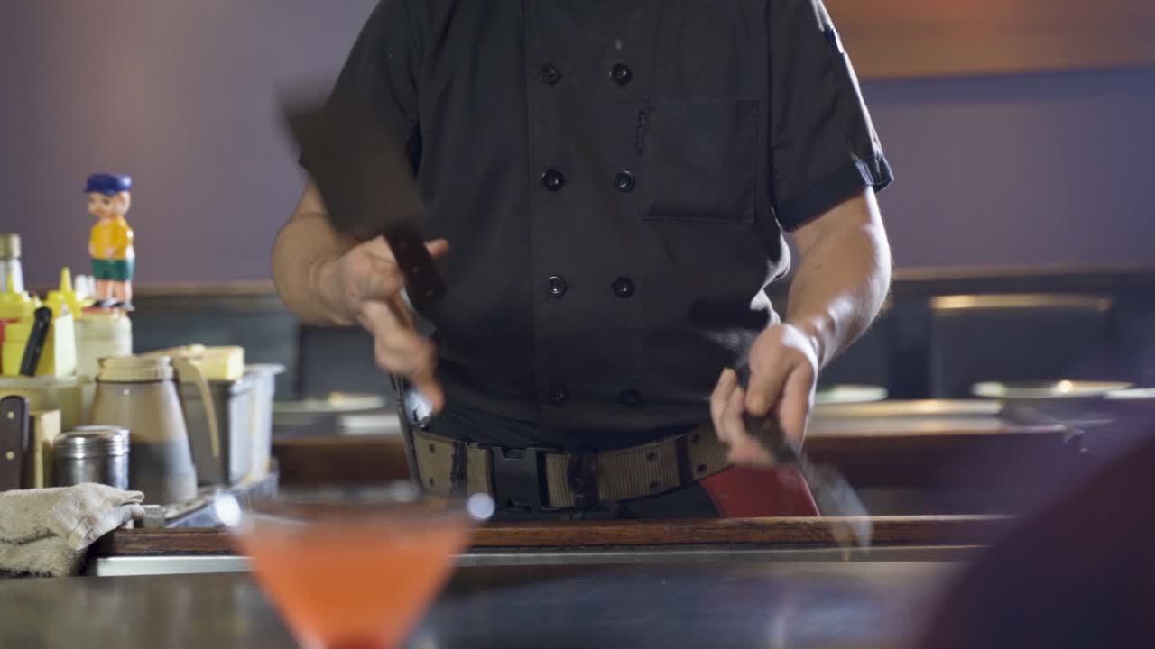 Rallentatore di uno chef Hibachi che lancia la sua spatola e forchetta in aria, Teppanyaki